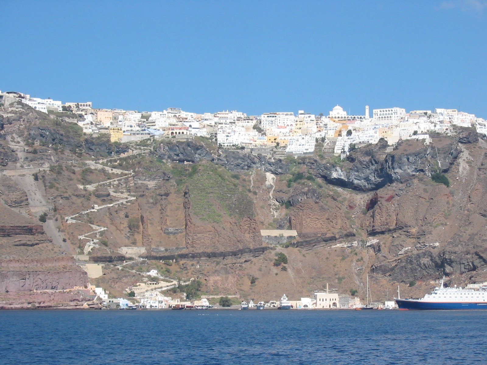 Fira town with white buildings on the Santorini caldera cliffs above the sea