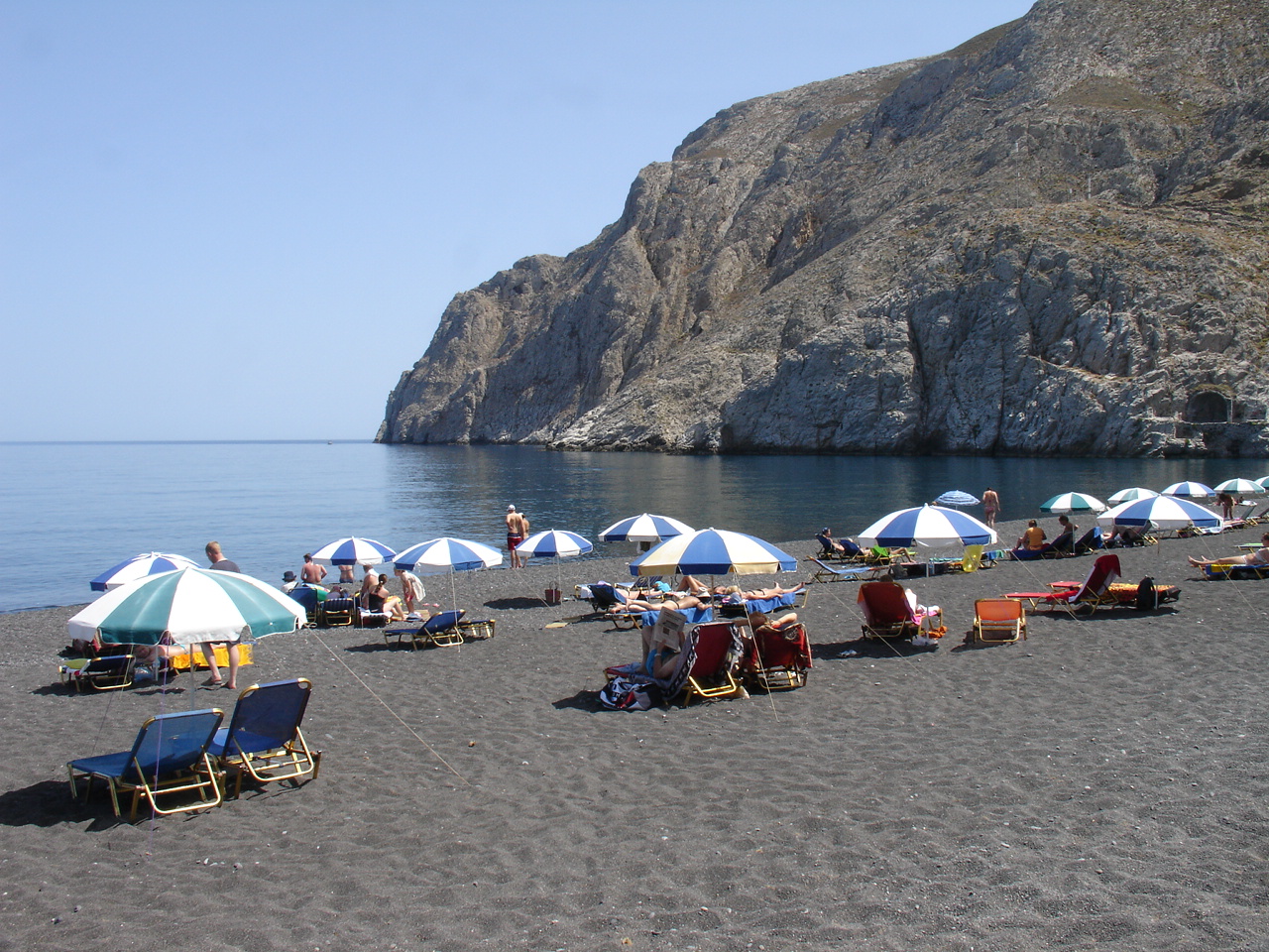 Kamari black sand beach and seaside promenade in Santorini